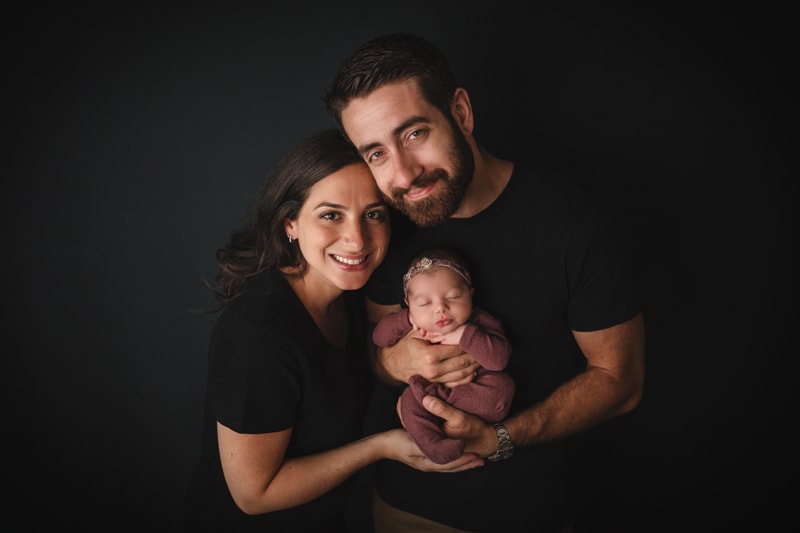 Newborn Photographer, A mother and father hold their newborn baby